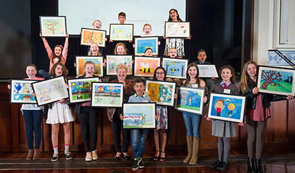 Group of children holding up their illustrations