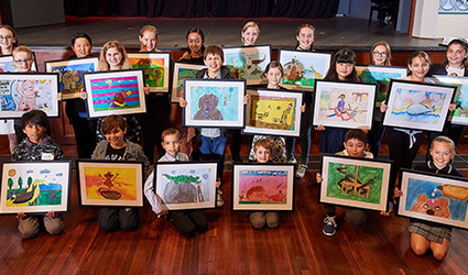 Children holding their framed artwork