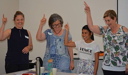 Four women learning key word sign