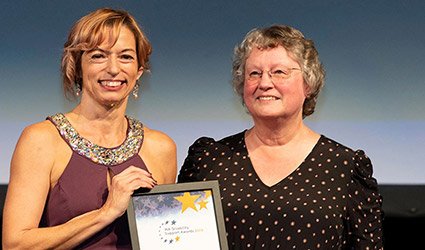 Woman accepting finalist award certificate