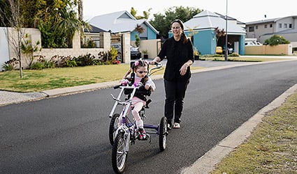 Little girl on bike with mum
