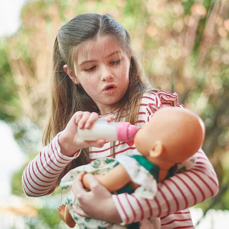 Girl has imaginative play with a doll