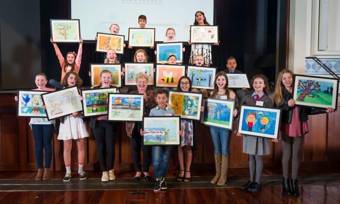 group of children holding up their illustrations