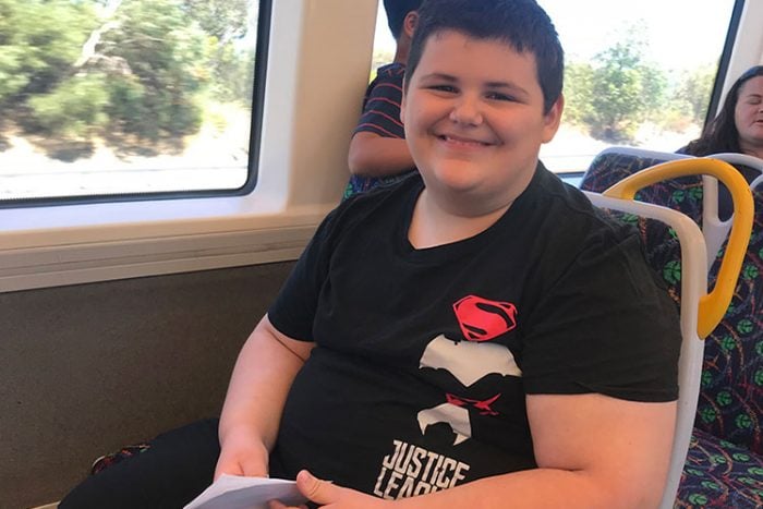boy sitting on train smiling