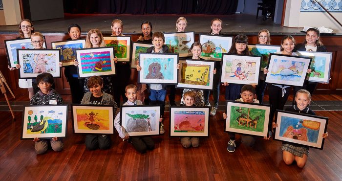 children holding their framed artwork