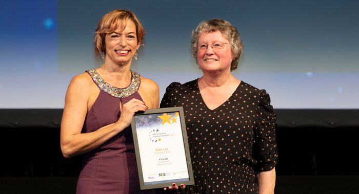woman accepting finalist award certificate