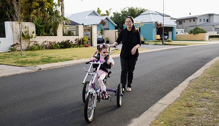 little girl on bike with mum