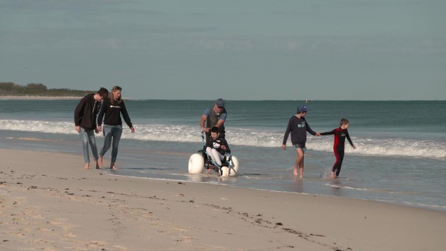 Harrison and his family walking along the beach