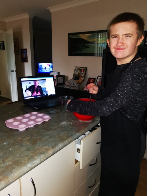 Ryan mixing in the kitchen as Christine watches via the laptop