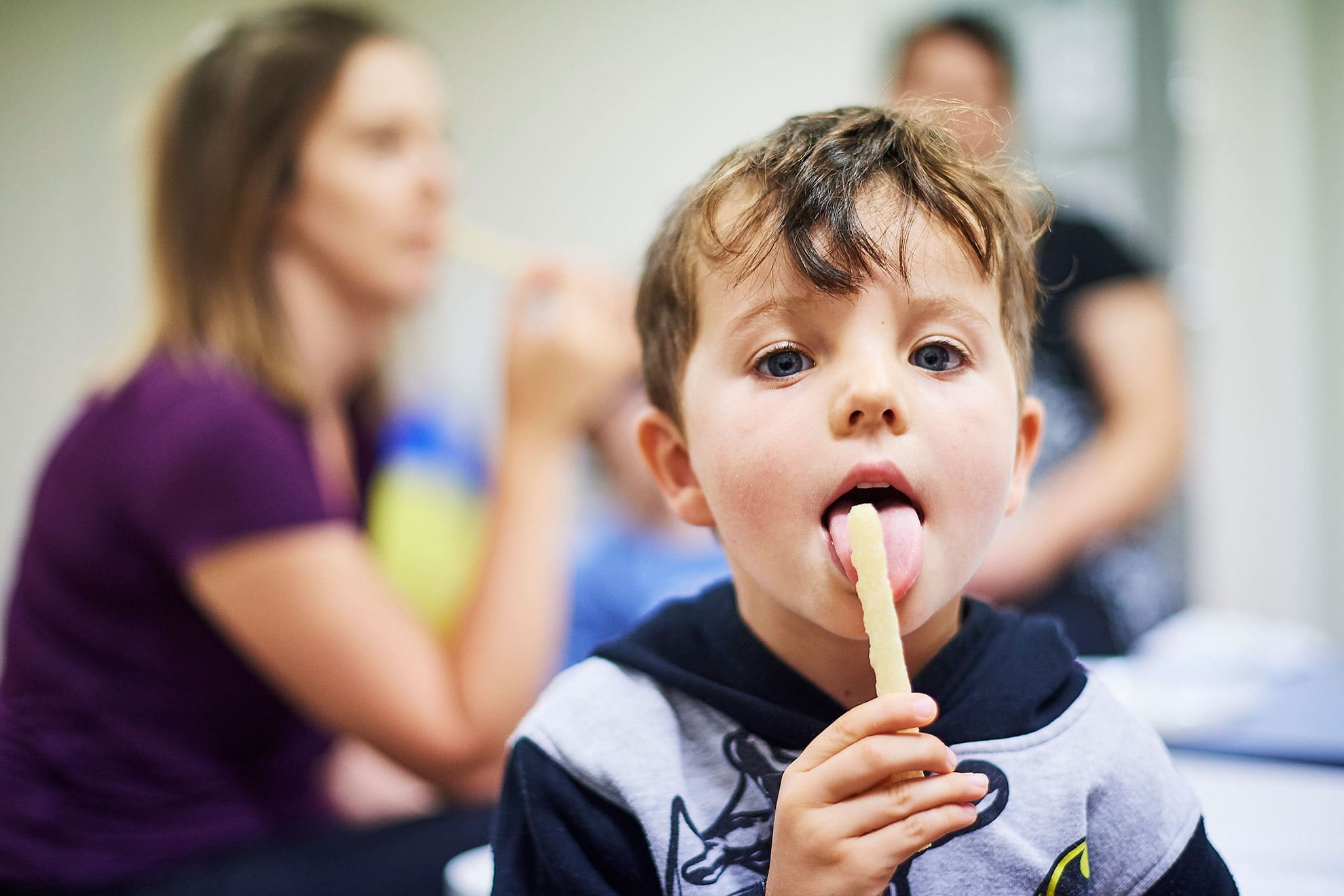 A young boy receiving dietetic services looks at camera while eating