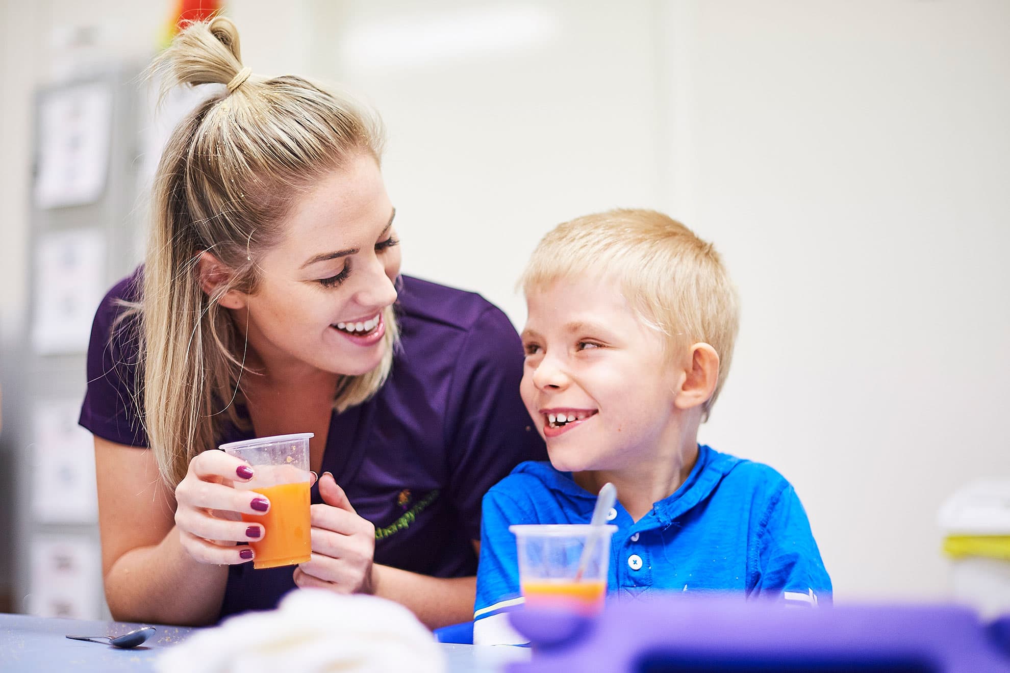 A therapist and boy smiling at each other during a mealtime management service