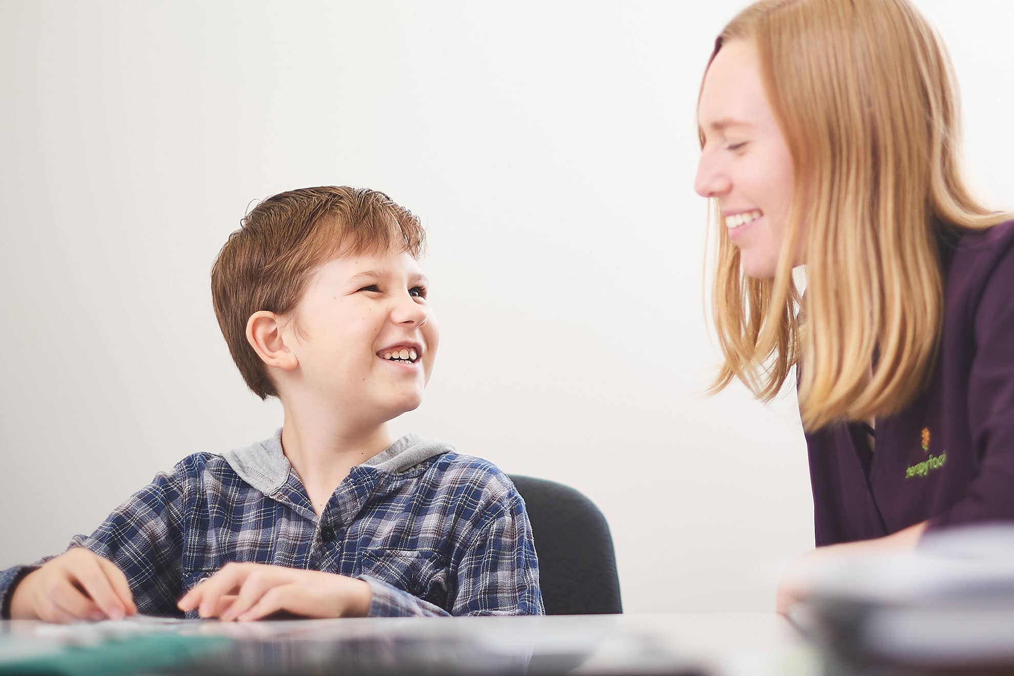 A boy smiling at his speech pathologist