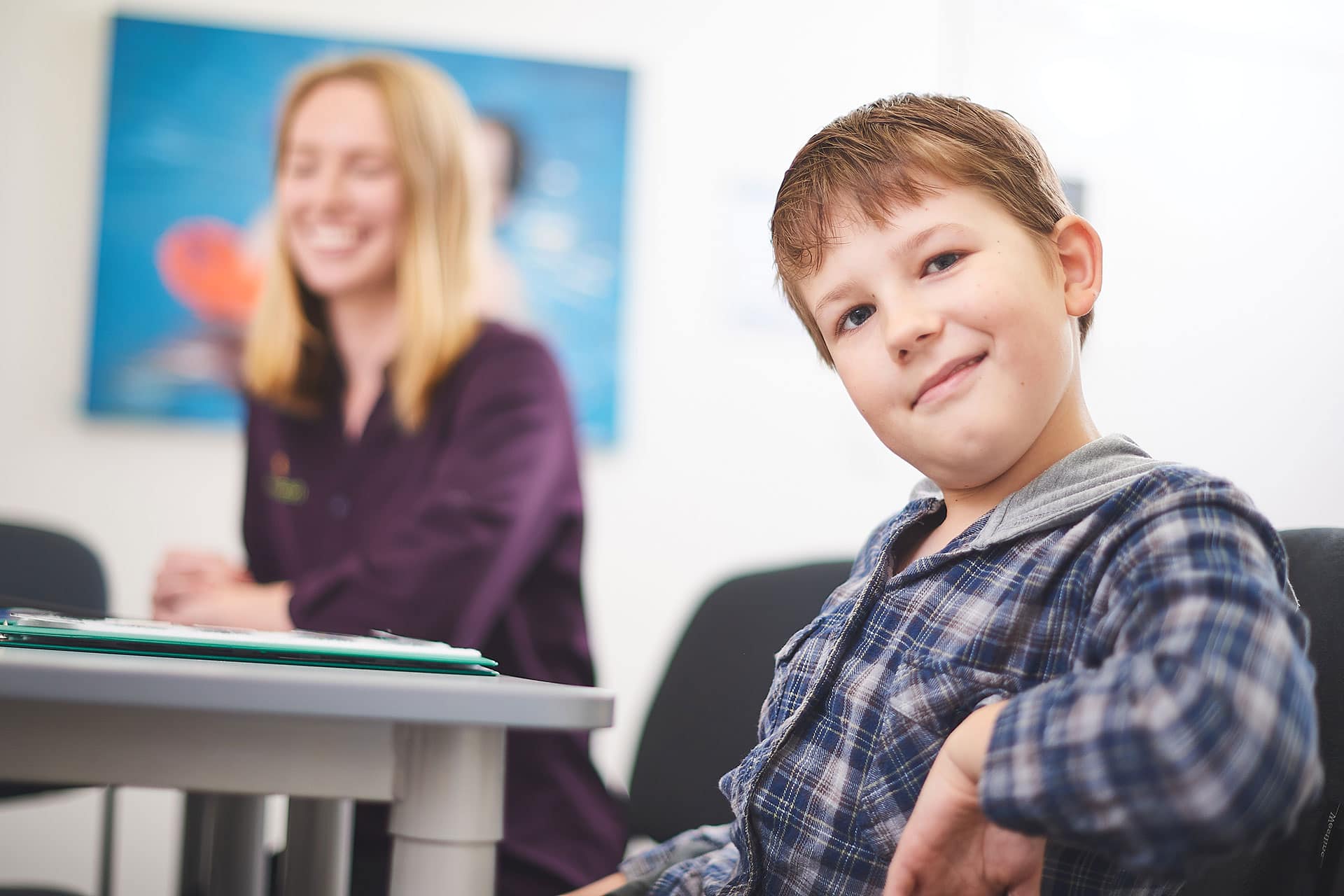 A boy smiling at the camera during a speech pathology service