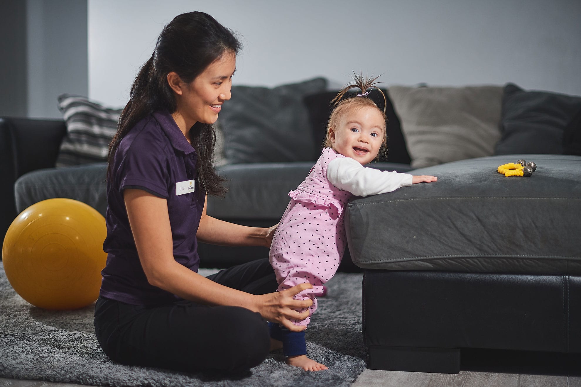 A baby with Down Syndrome with a therapist during a early childhood intervention session