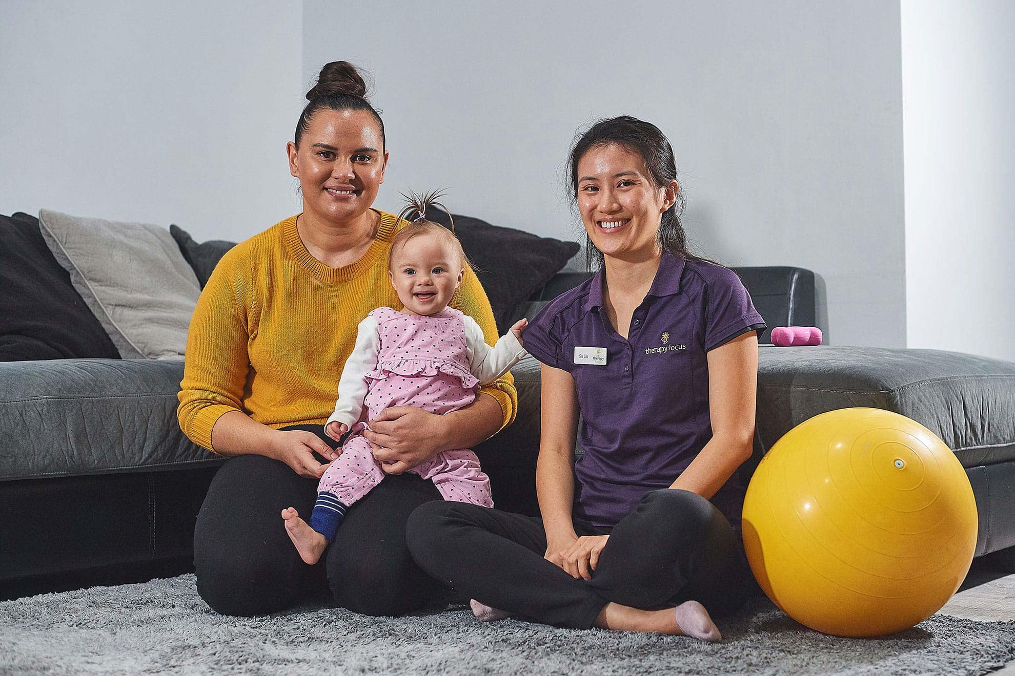 A mother with her baby sitting next to a therapist