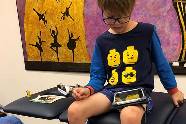 A therapist drawing on Jack's cast with West Coast Eagles colours