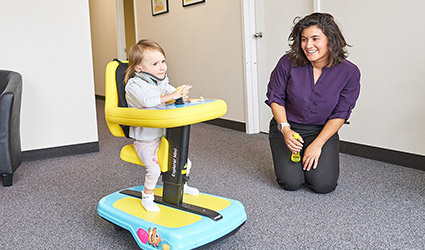 Olivia smiling as she uses the Explorer Mini with her therapist.