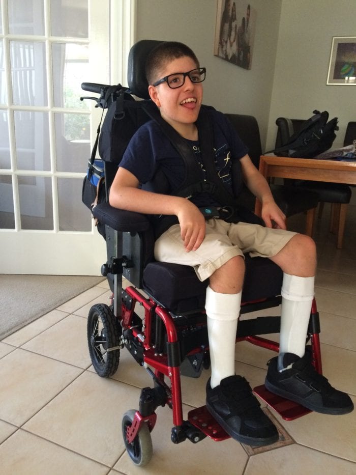 Harrison sits in his completed wheelchair. 