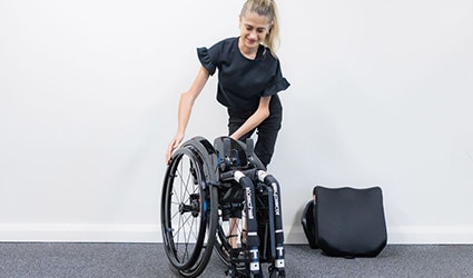 A customer folds away her wheelchair.