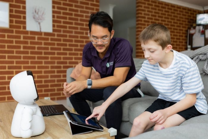A customer and therapist interact with a social robot.