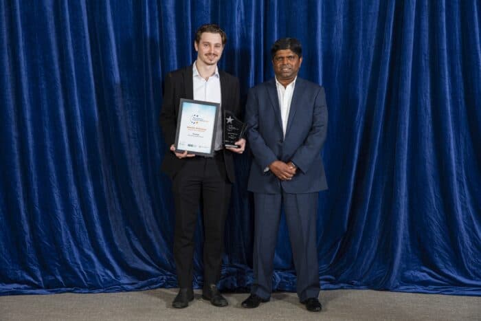 Hamish accepts his award from Kanishka