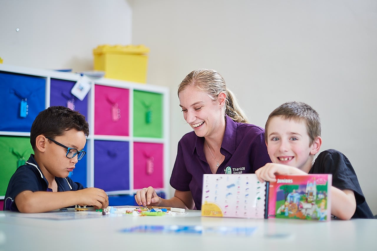 Graduate therapist works with two customers in a Lego group