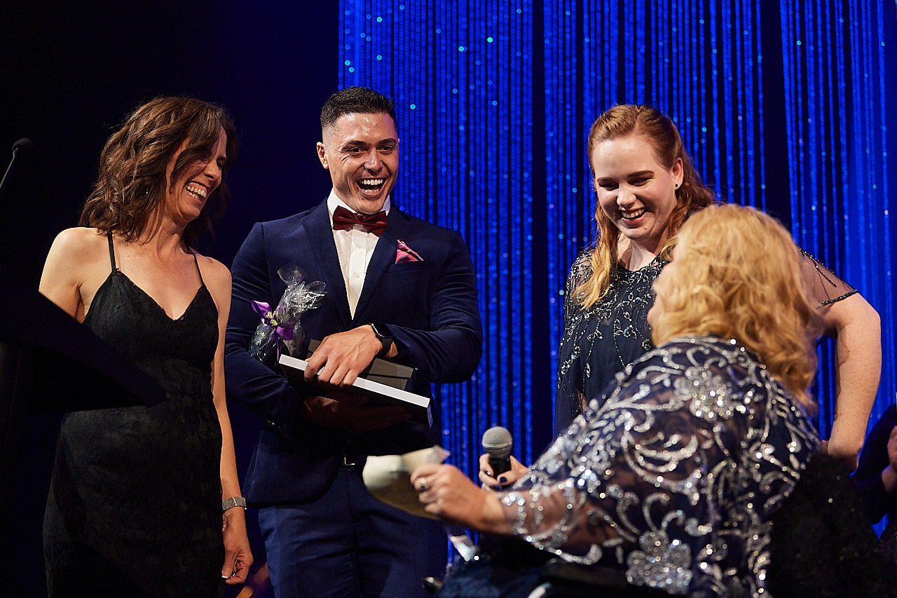 Therapist accepting an award from a lady using a wheelchair