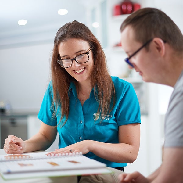 A therapist showing a customer where to sign