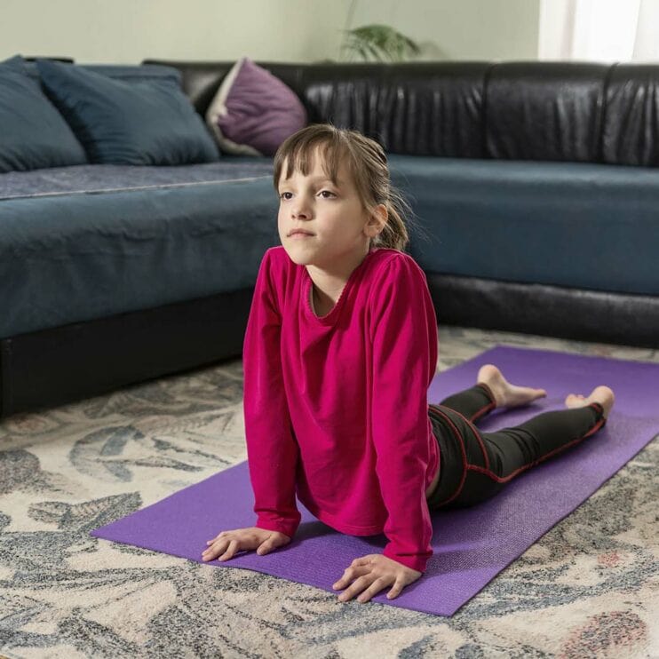 Young girl practising yoga at home