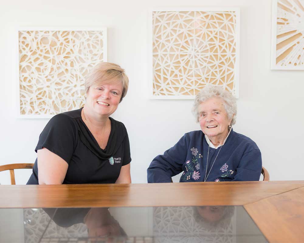 A Therapy Focus clinician and elderly lady smiling