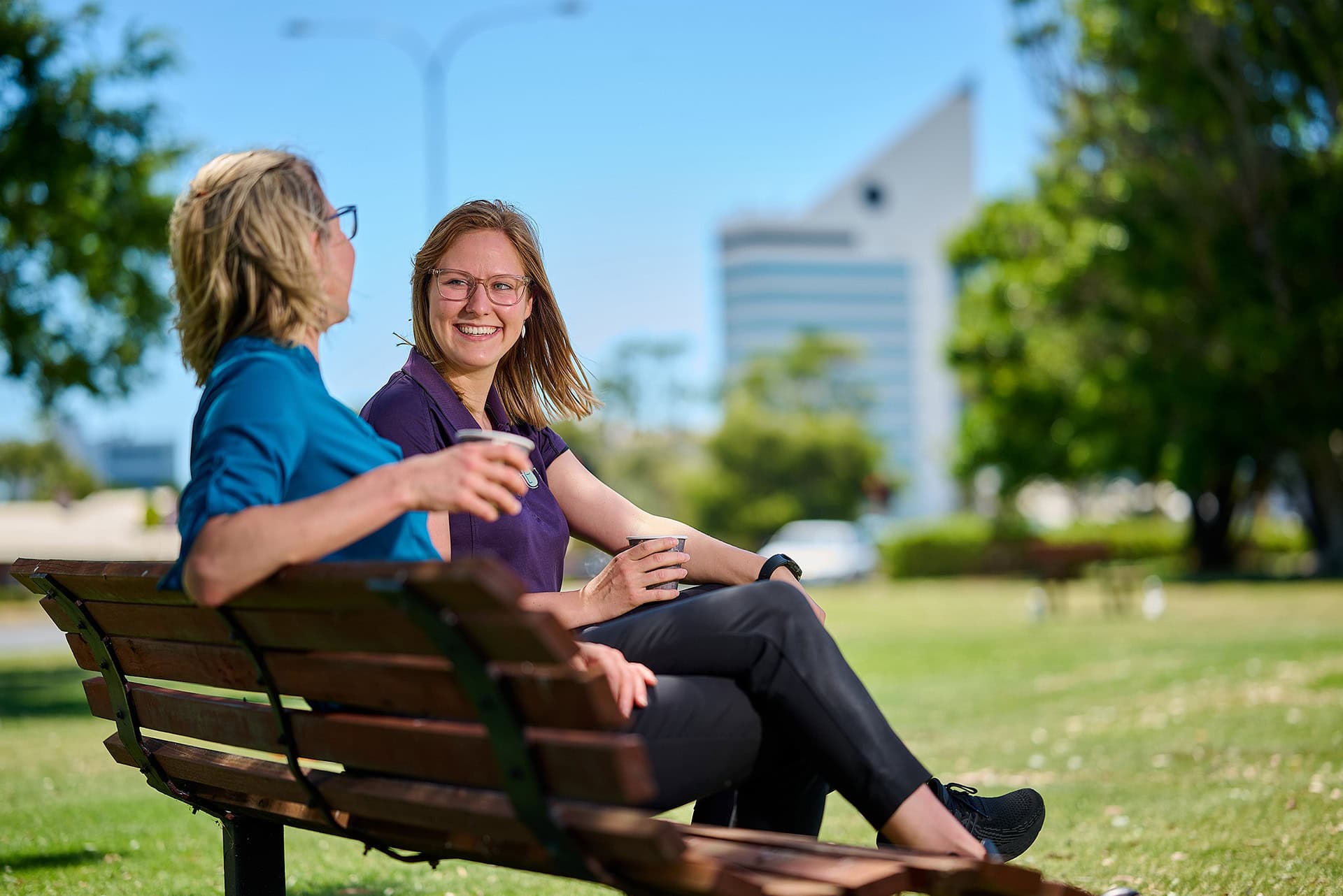 Two therapists chat on park bench in Bunbury